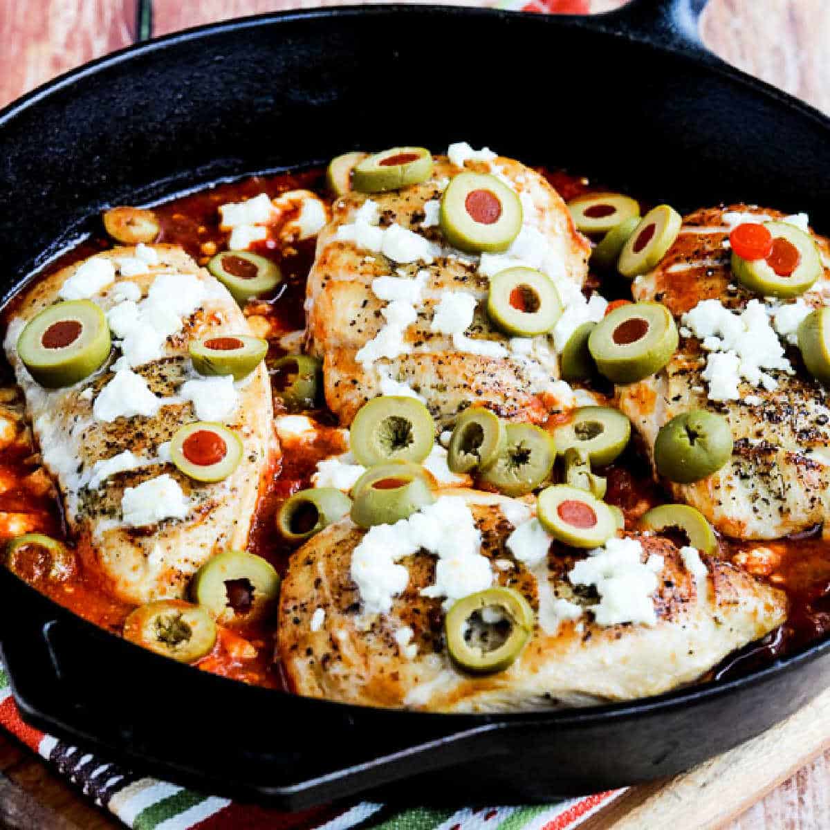 Square image of Greek Skillet Chicken shown in cast iron pan