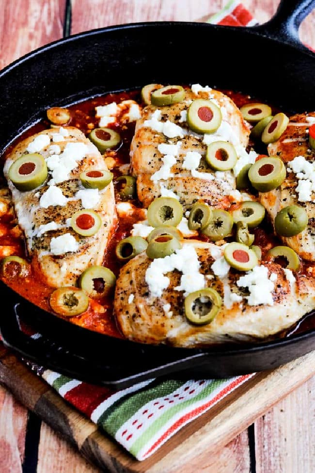 Greek Skillet Chicken shown in pan with melted Feta and Green Olives.