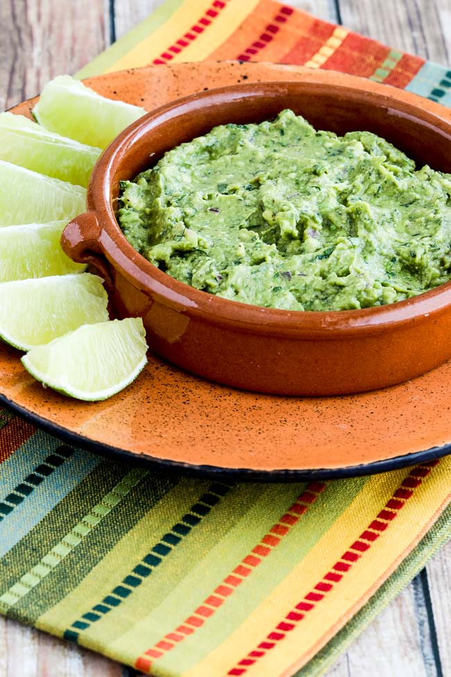 Cilantro-Lovers Perfect Guacamole in serving bowl with limes