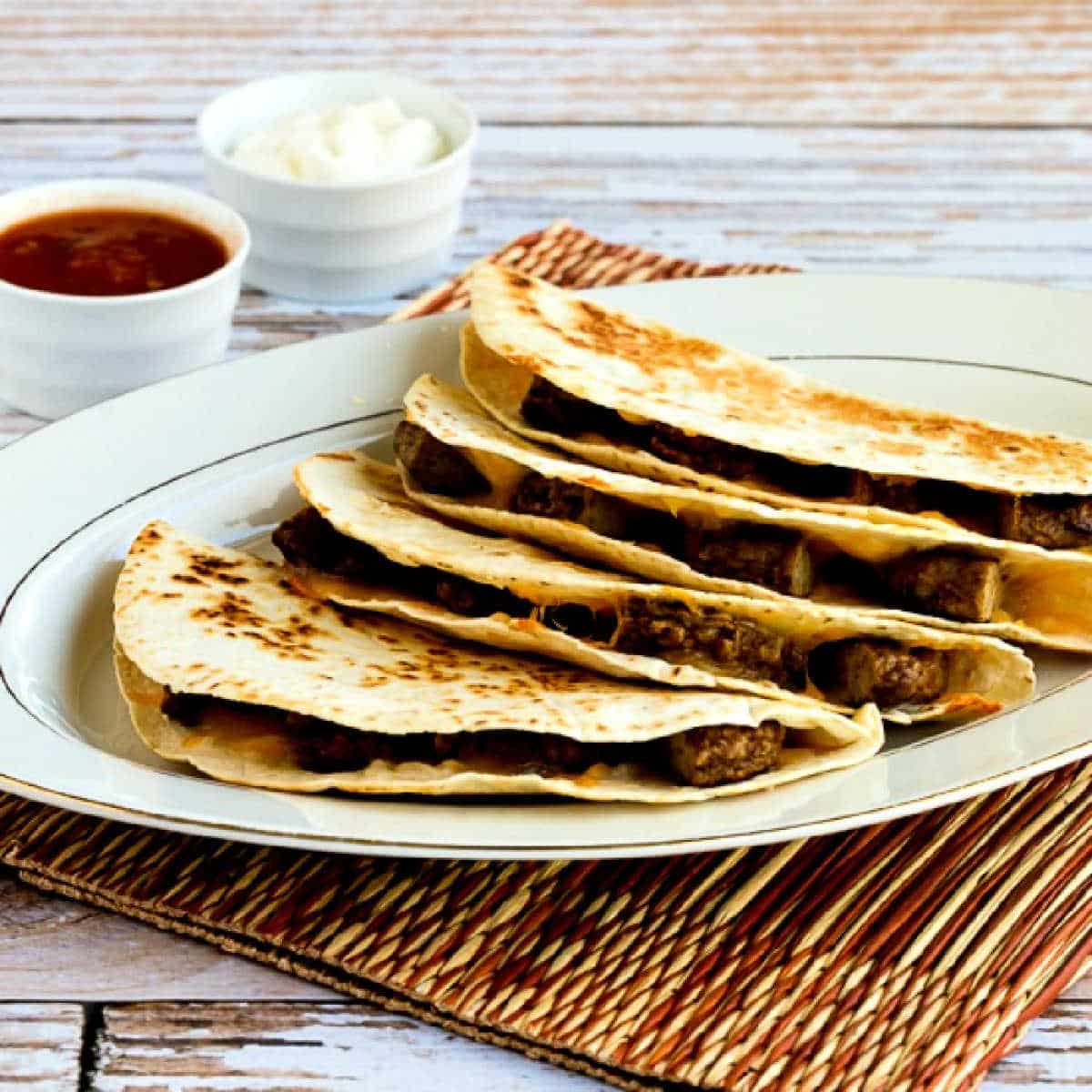 Square image of Sausage and Cheese Breakfast Quesadillas on serving plate.
