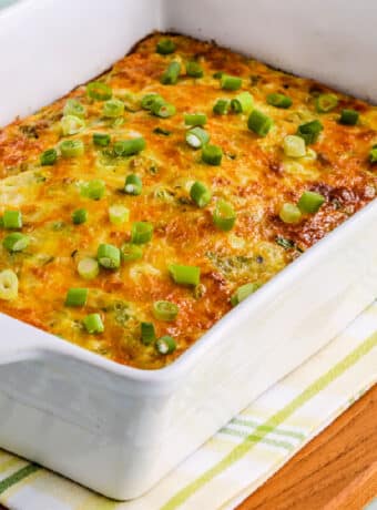 Square image of Cheesy Green Chile Breakfast Casserole shown in baking dish.