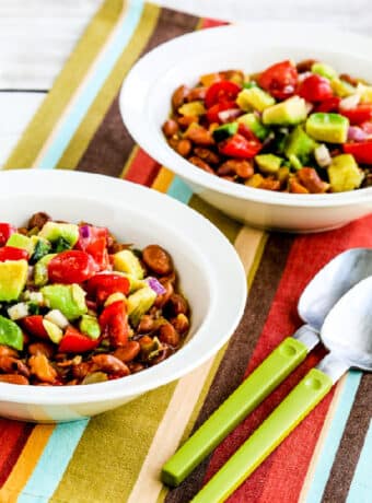 Instant Pot Mexican Beans in two serving bowls on napkin with spoons.