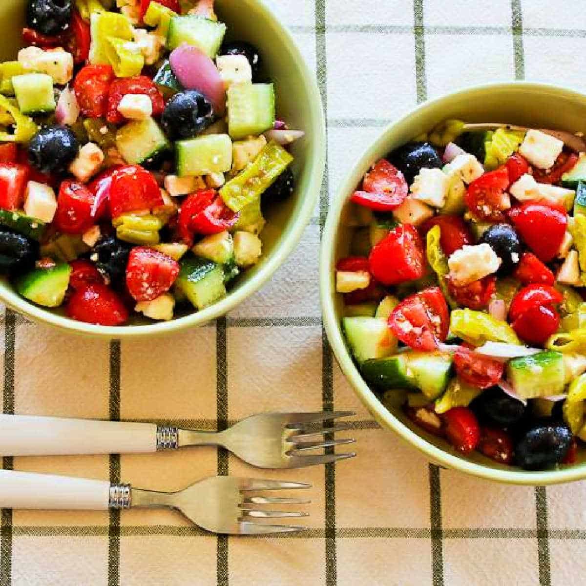 Chopped Greek Salad with Peperoncini shown in two serving bowls.