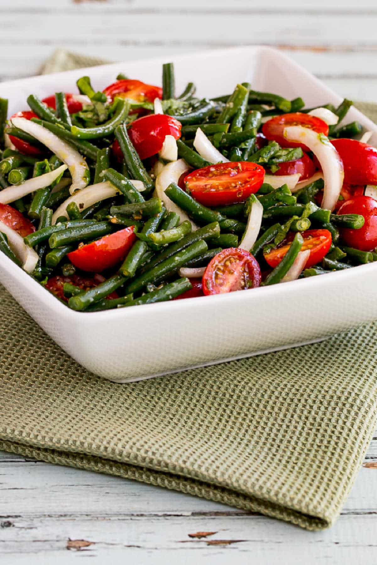 Green Bean Tomato Salad in serving bowl on green napkin