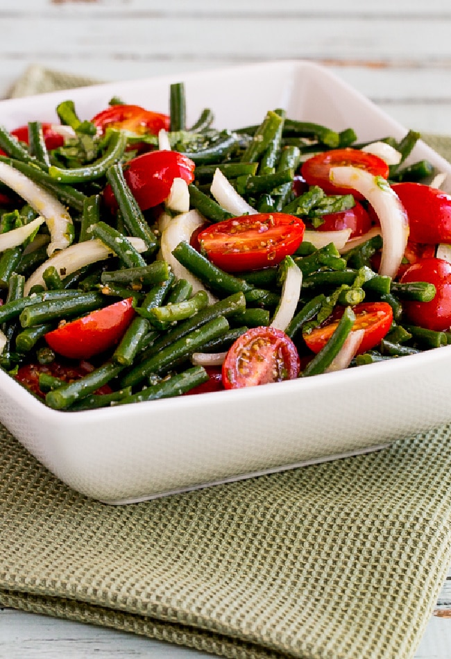 Green Bean and Tomato Salad shown in serving bowl on green napkin