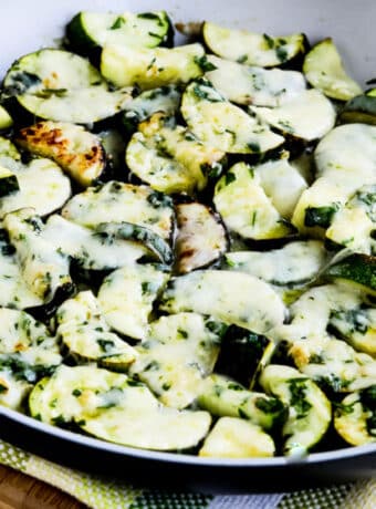 Cheesy Zucchini with Garlic and Parsley shown in frying pan.