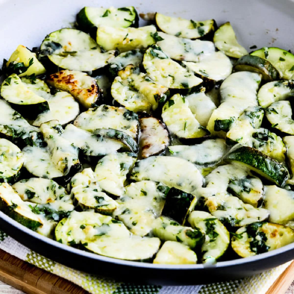 Cheesy Zucchini with Garlic and Parsley shown in frying pan.