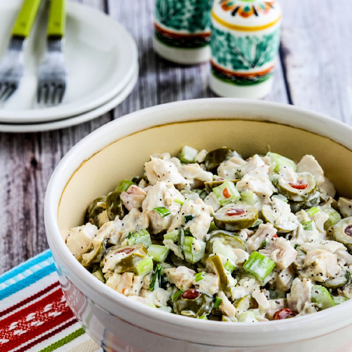 Square image of Chicken Salad with Green Olives shown in large serving bowl.
