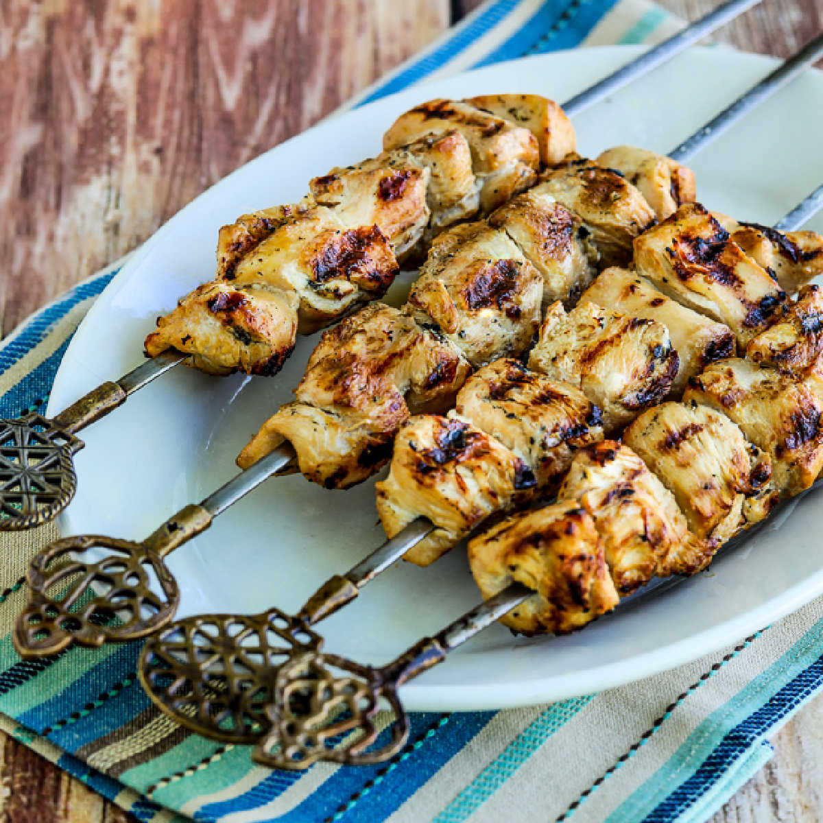 Four Turkey Kabobs shown on serving plate with napkin and decorative skewers.