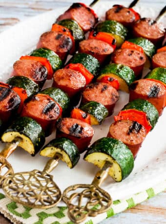 Easy Kabobs with Zucchini and Sausage shown on skewers on serving plate.