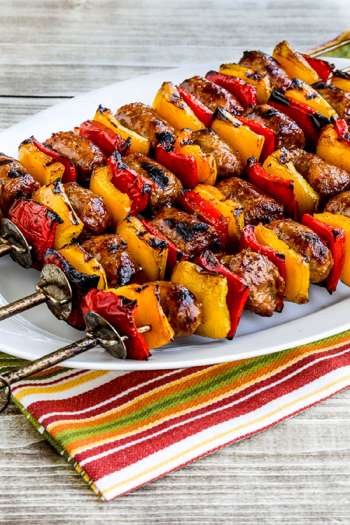 Grilled Sausage and Peppers kabobs shown on serving plate