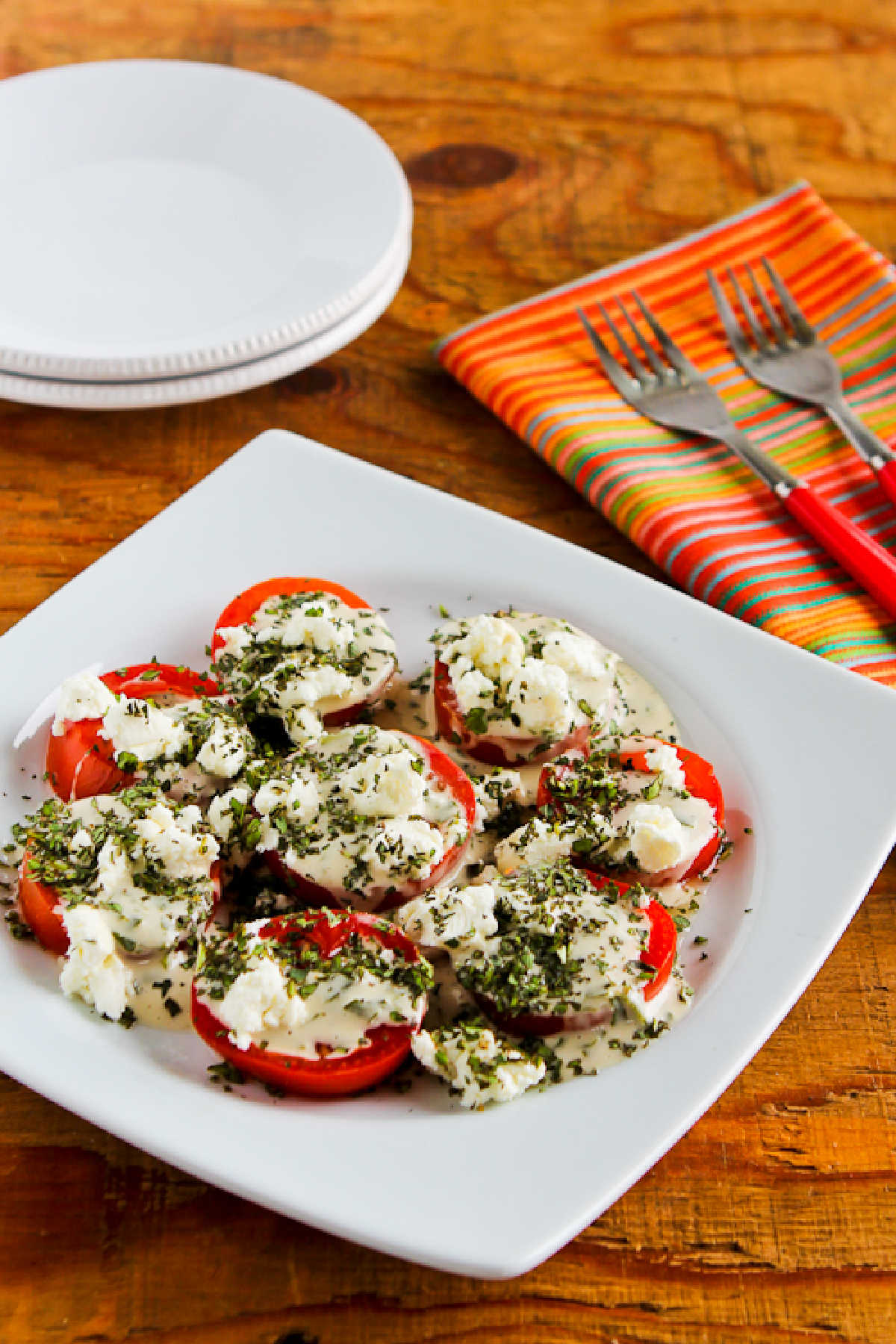 Summer Tomato Salad with Goat Cheese on serving plate with red napkin