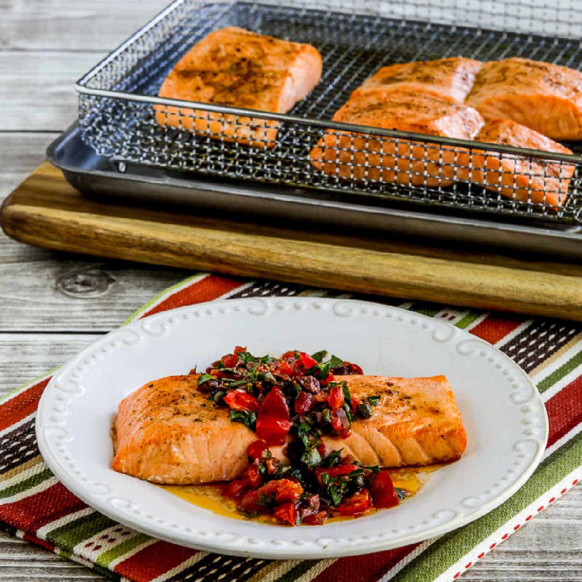Square image for Salmon with Tomato Olive Relish on serving plate with Air Fryer salmon in back.