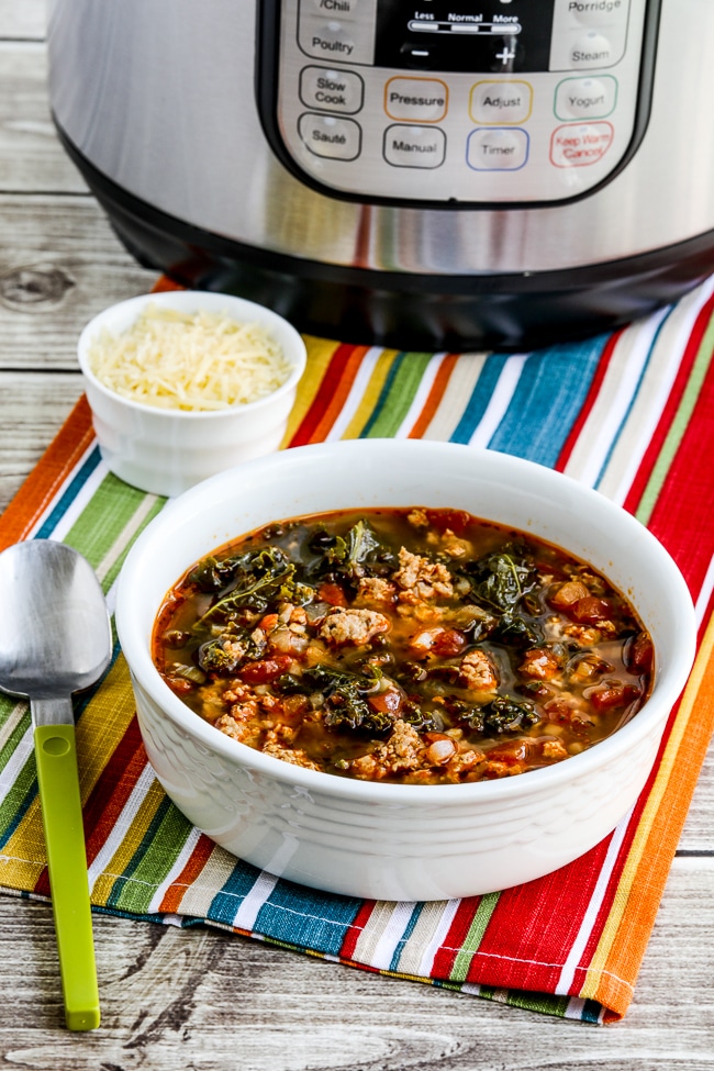 Instant Pot Sausage and Kale Soup in bowl with Instant Pot in background