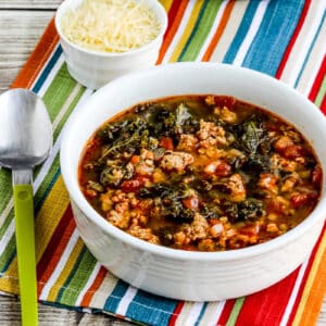 square image of Instant Pot Sausage and Kale Soup in soup bowl with Parmesan in background