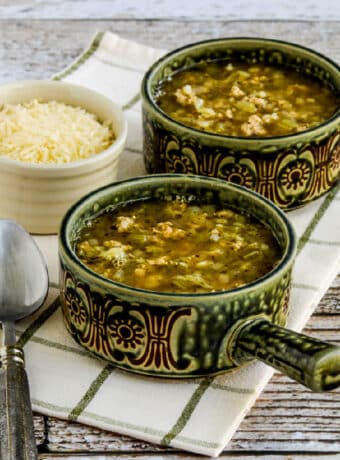 square image of Instant Pot Turkey Rice Soup with Cabbage in two soup bowls with Parmesan