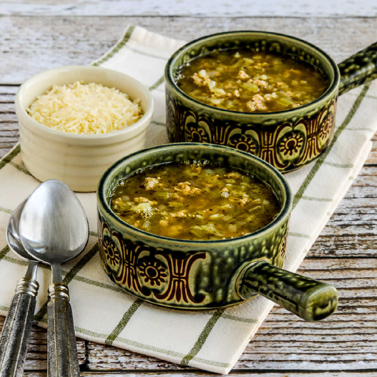 square image of Instant Pot Turkey Rice Soup with Cabbage in two soup bowls with Parmesan