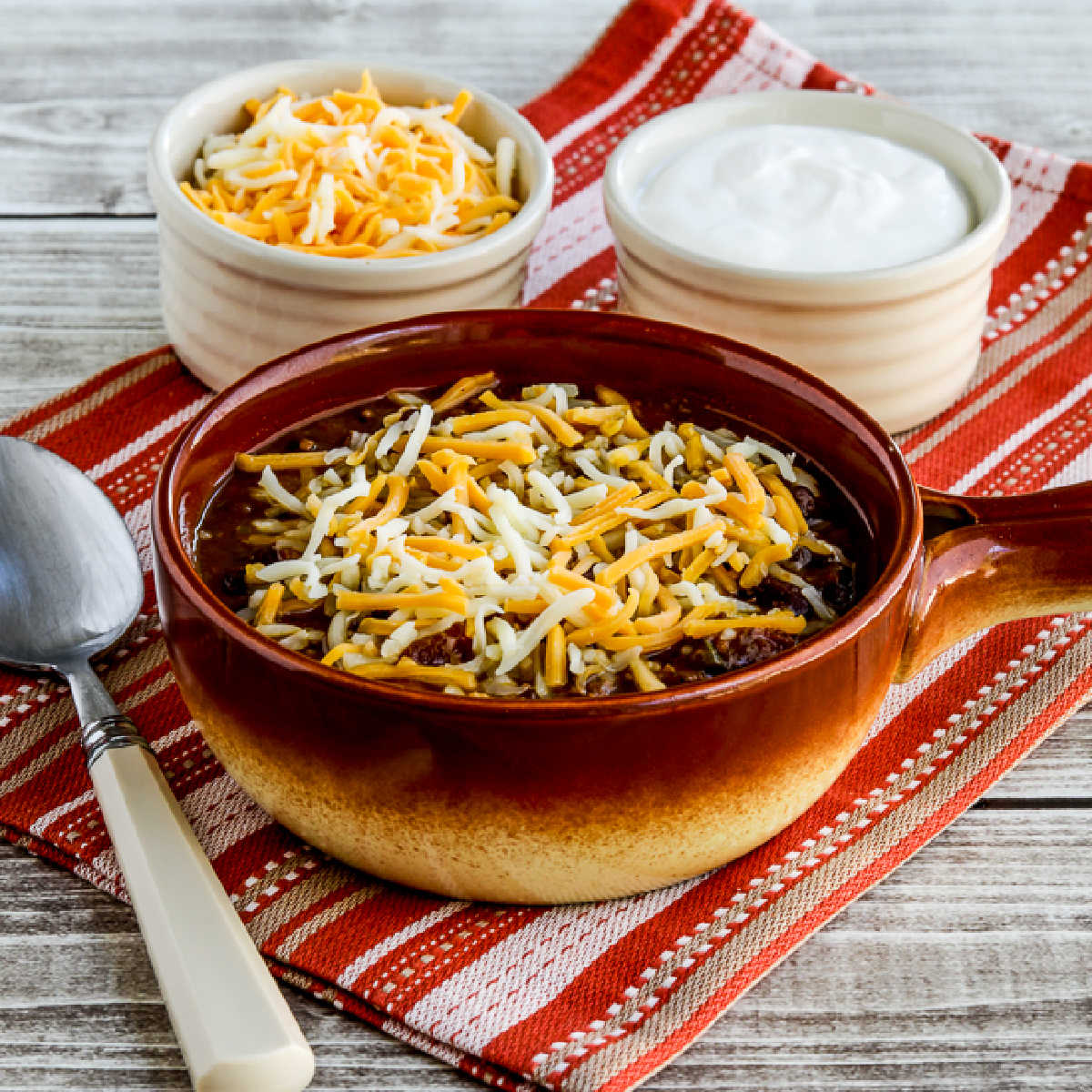 square image of Pumpkin Chili with Ground Beef with grated cheese