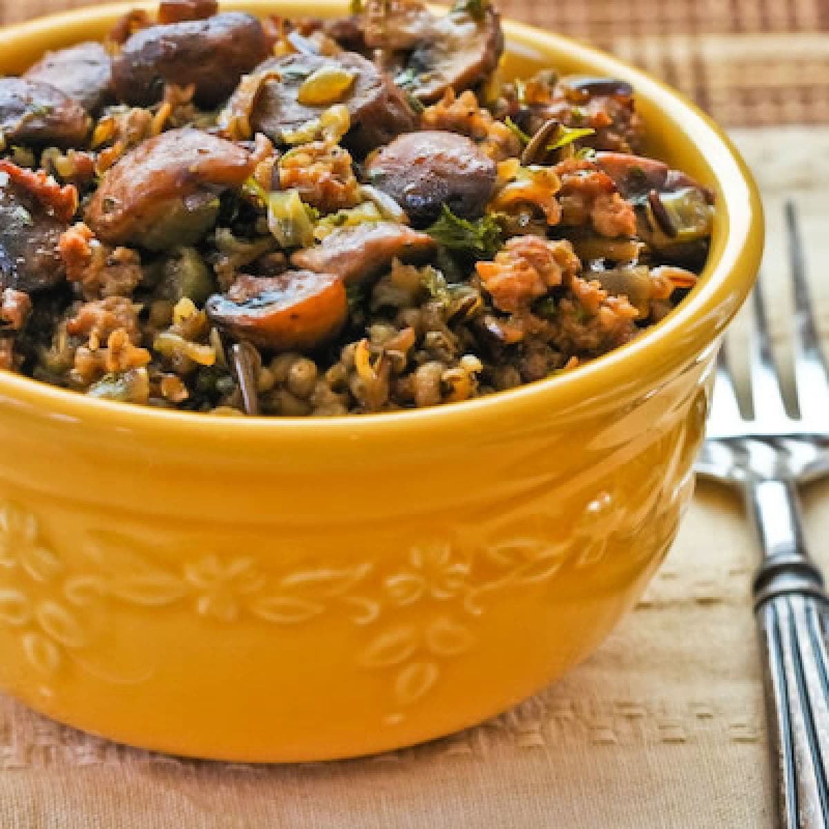 Square image for Wild Rice Stuffing with Sausage and Mushrooms shown in serving bowl.