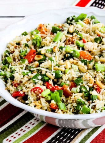 Square image for Roasted Cauliflower Rice Medley with red pepper and pine nuts, shown in serving bowl.
