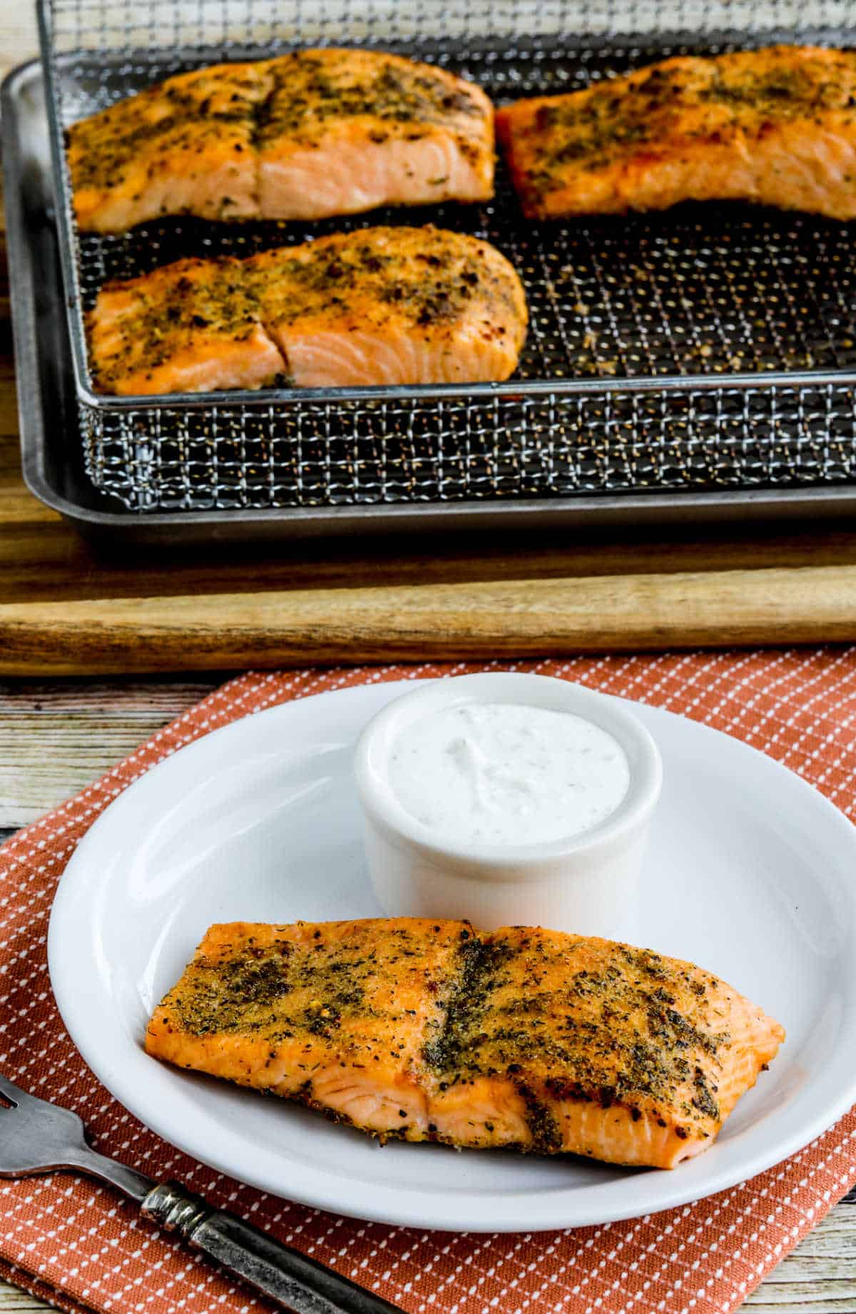 Greek Salmon cooked in air fryer, shown on serving plate with Tzatziki