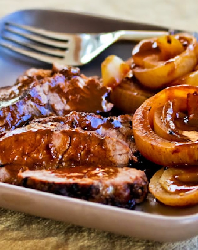 Slow Cooker Balsamic and Onion Pot Roast shown on serving plate with fork.