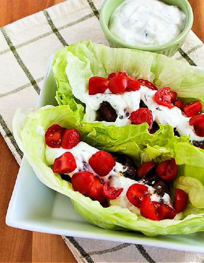 Gyro Meatballs made into lettuce wraps, shown in serving dish with Tzatziki in back.