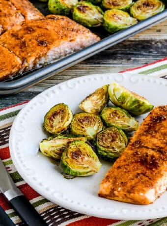 Square image of Salmon with Brussels Sprouts Sheet Pan Meal shown on baking pan.