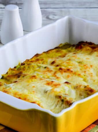 Square image for Cheesy Curry Chicken Casserole shown in casserole dish with salt-pepper in back.