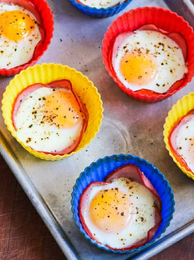 Baked Eggs in Canadian Bacon Cups shown on baking sheet