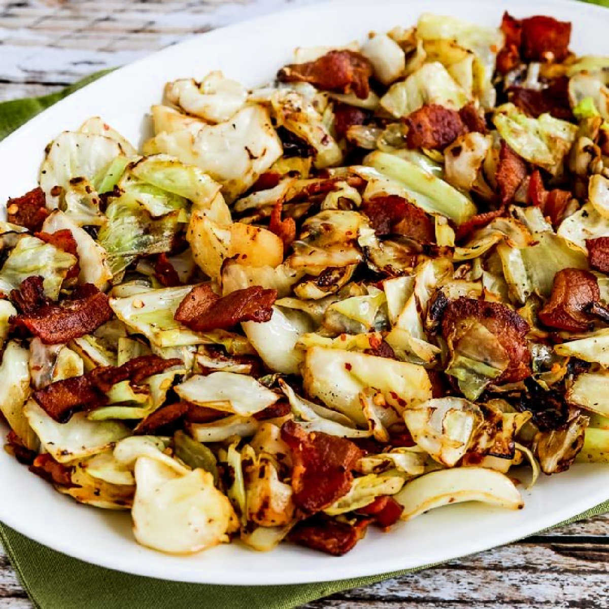 A square image of fried cabbage with bacon is displayed on a serving plate.