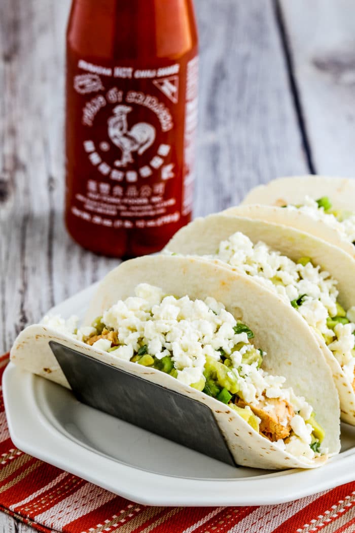 Instant Pot Sriracha Chicken Tacos finished tacos on plate with Sriracha and Queso Fresca