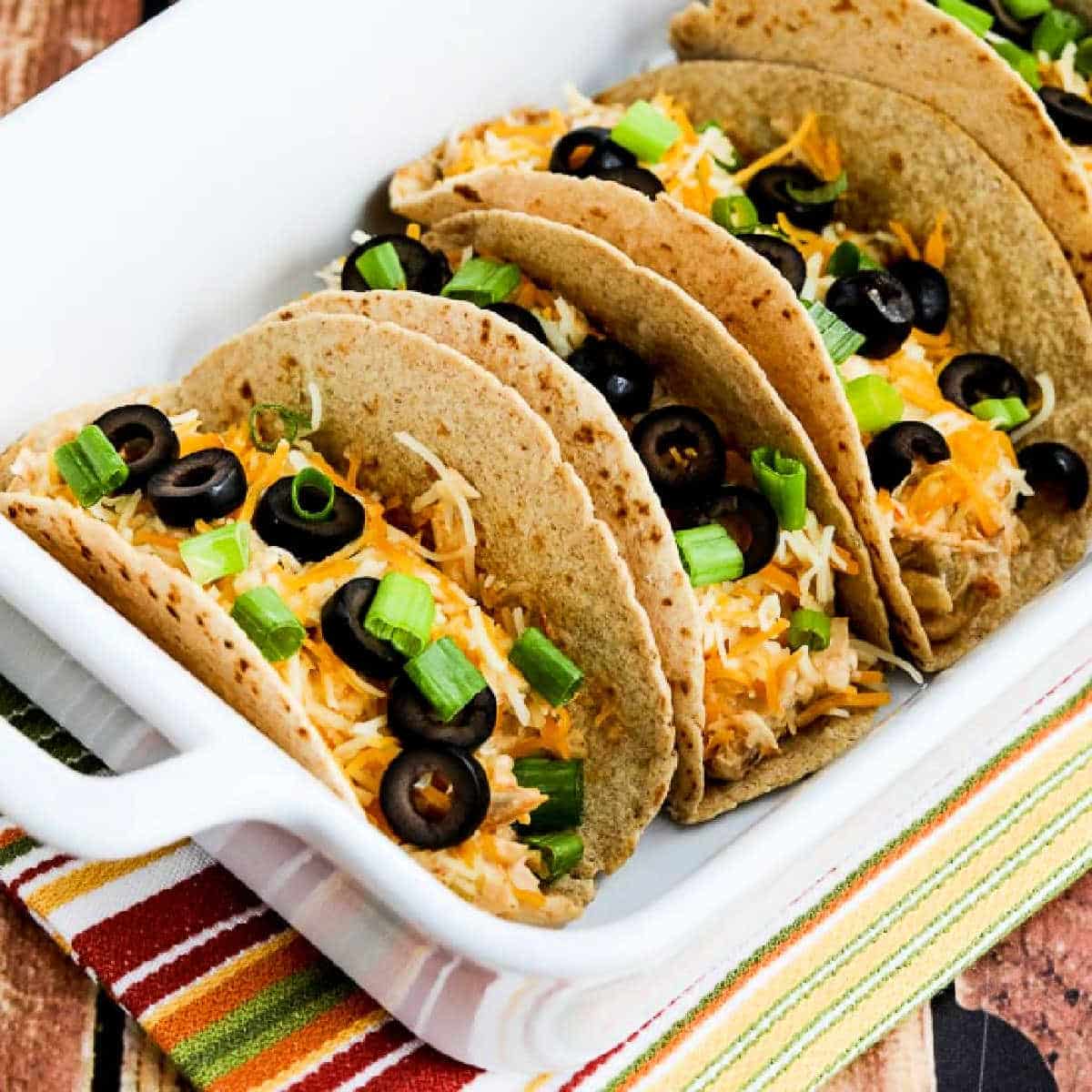 Square image of Instant Pot Cheesy Chicken Tacos shown in serving dish.