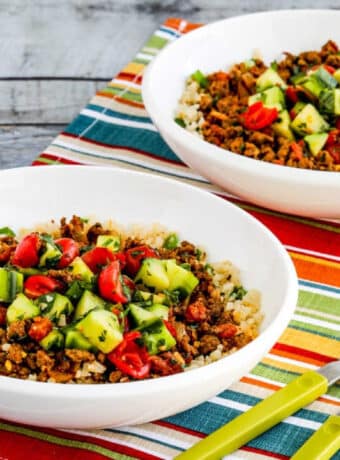 Middle Eastern Ground Beef Bowls shown in two bowls on napkin with green forks.