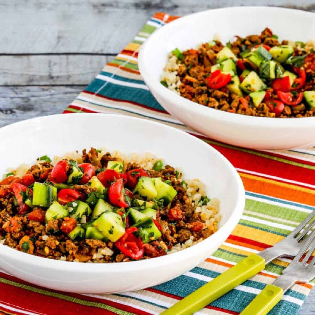 Middle Eastern Ground Beef Bowls shown in two bowls on napkin with green forks.