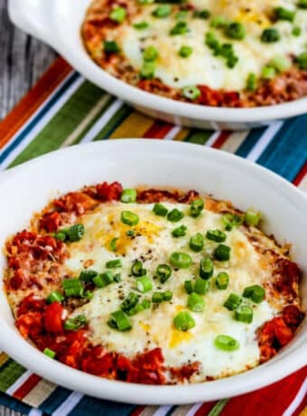 Square image for Tuscan Baked Eggs with Tomatoes shown in two gratin dishes.