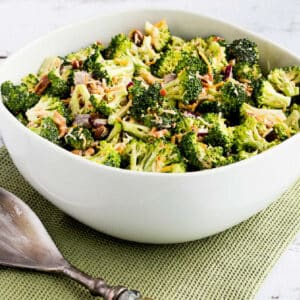 Square image for Sweet and Sour Broccoli Salad in white bowl on green napkin.
