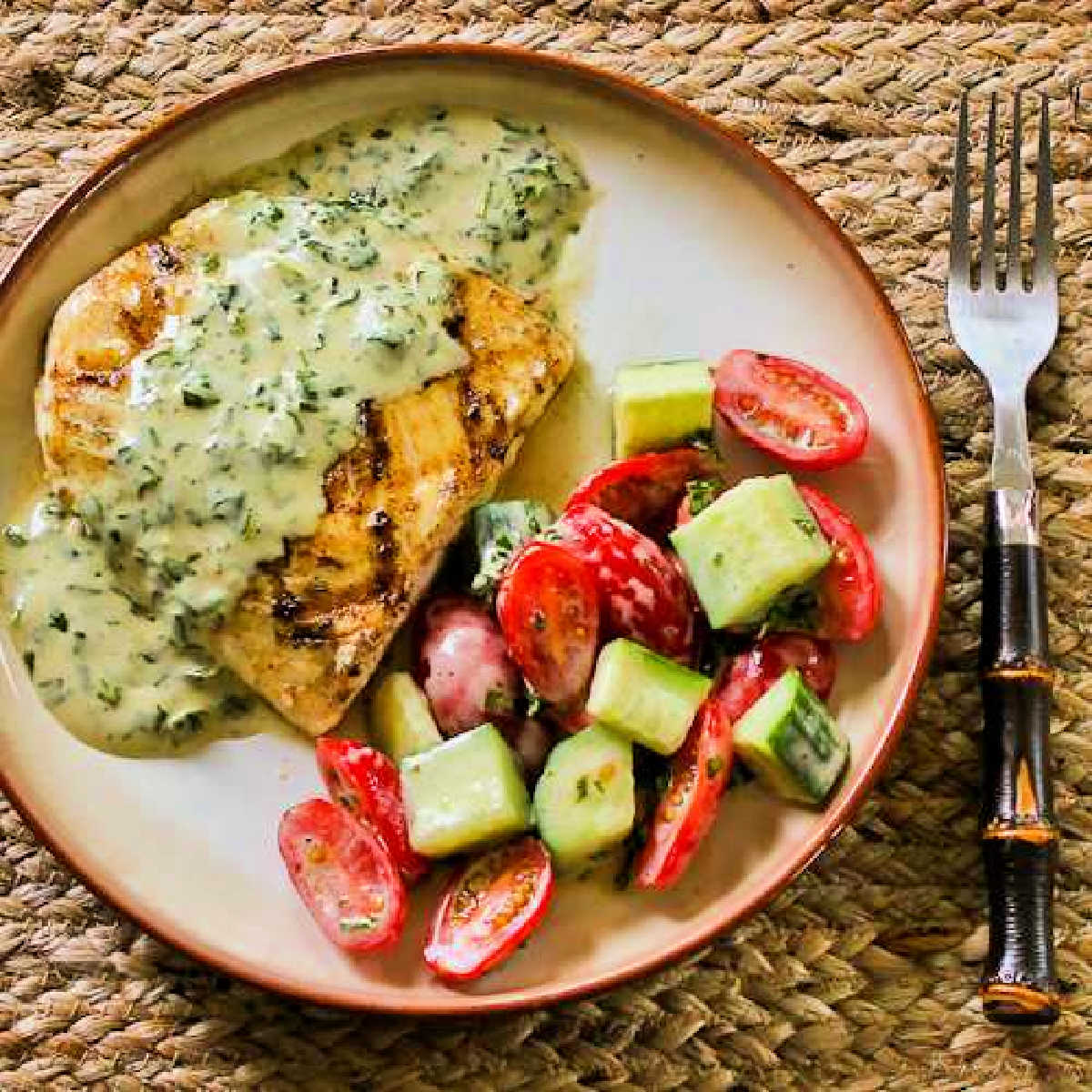 Grilled Halibut with Basil Vinaigrette on serving plate with tomato-cucumber-salad
