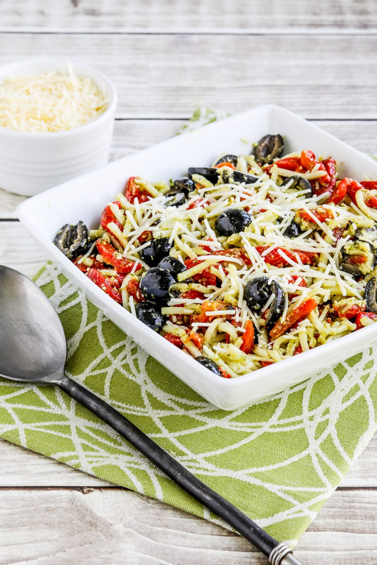 Pesto Pasta Salad in serving bowl with tomatoes and olives