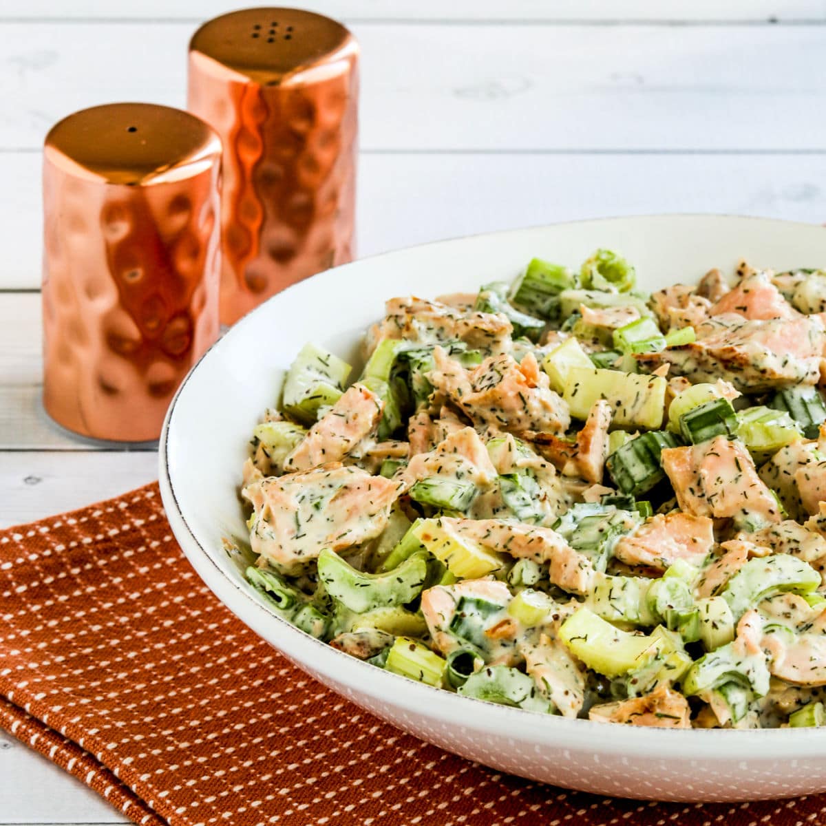 Salmon Salad with Dill in serving dish with salt and pepper shakers in back.