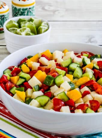 Laurel's Jicama Salad shown in serving bowl with limes and Mexican salt-pepper in back.