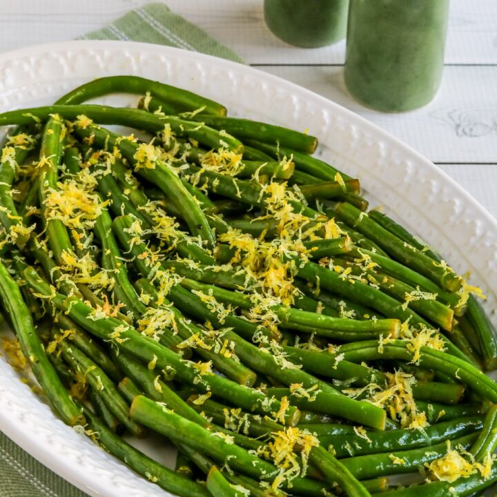 Lemon Green Beans shown on serving plate, with salt and pepper in back.