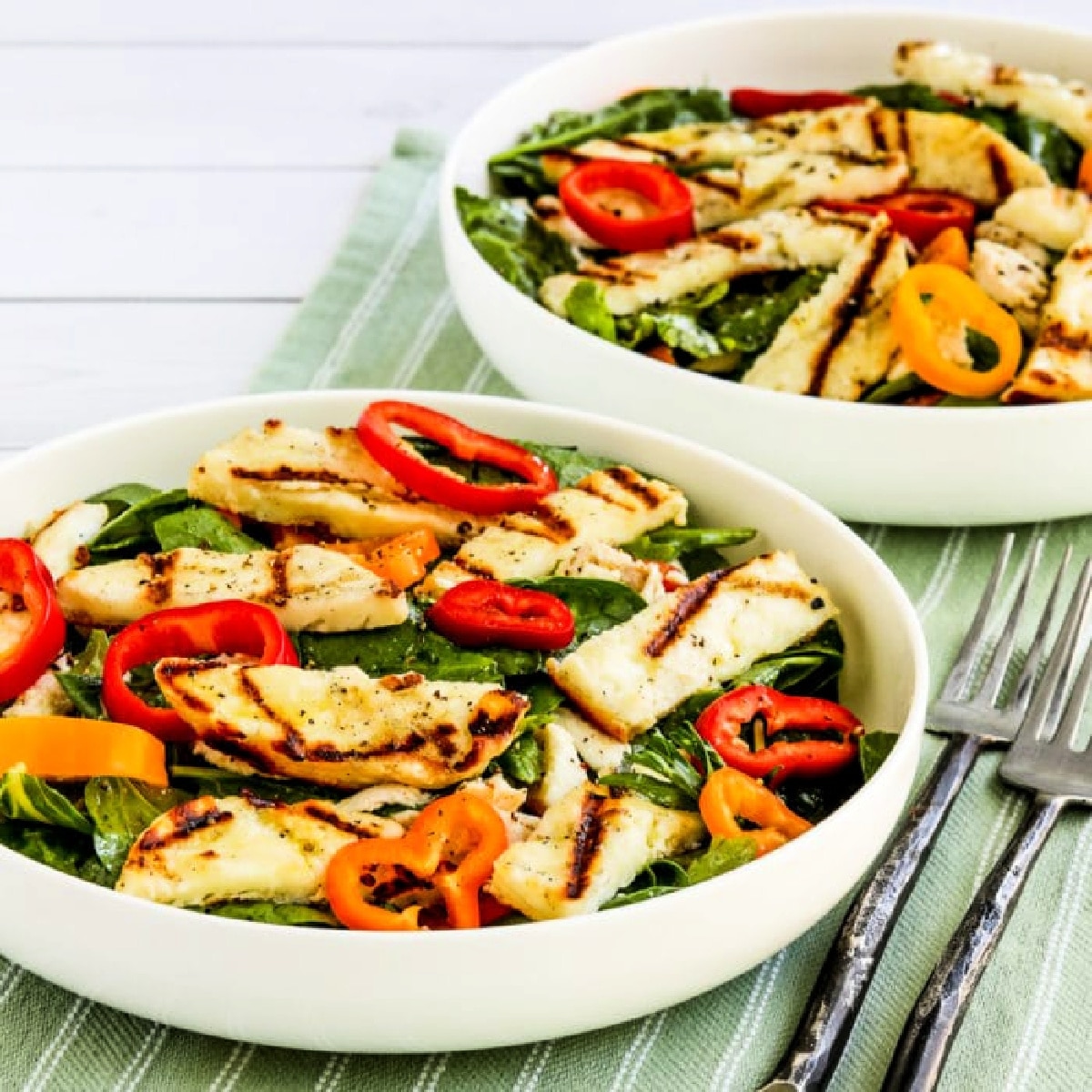 Grilled Halloumi Salad shown in two bowls on napkin.