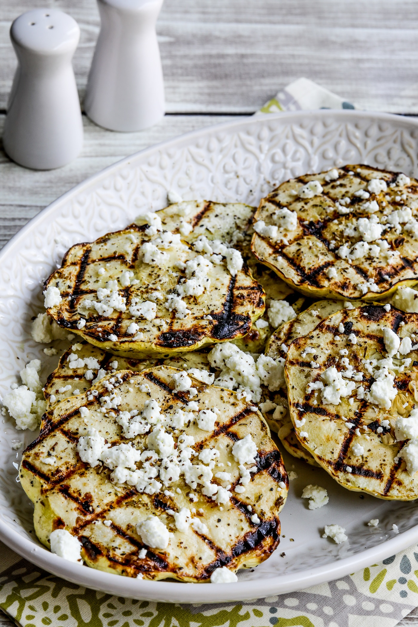 close-up photo of Grilled Patty Pan Squash in serving dish with crumbled goat cheese