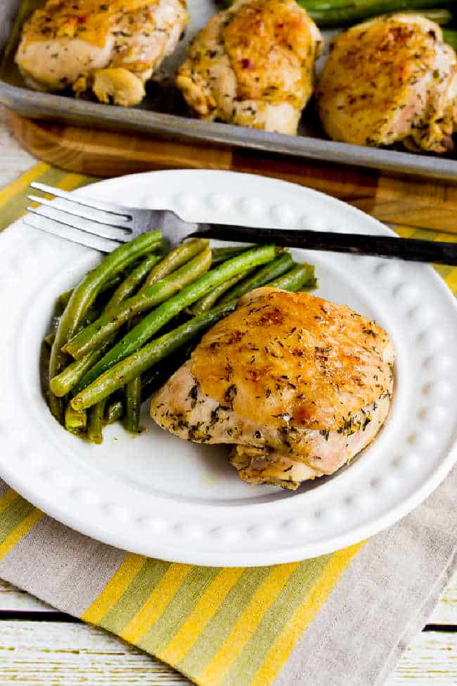 Chicken and green beans sheet pan meal shown on serving plate with sheet pan in background