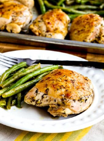 square image of Chicken and green beans sheet pan meal with one serving on plate and sheet pan in background