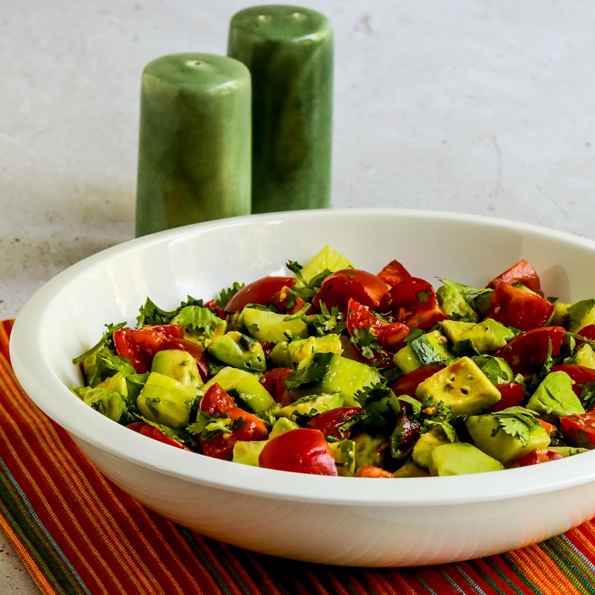 Square image for Tomato Salad with Cucumbers, Avocado, and Cilantro in white bowl.