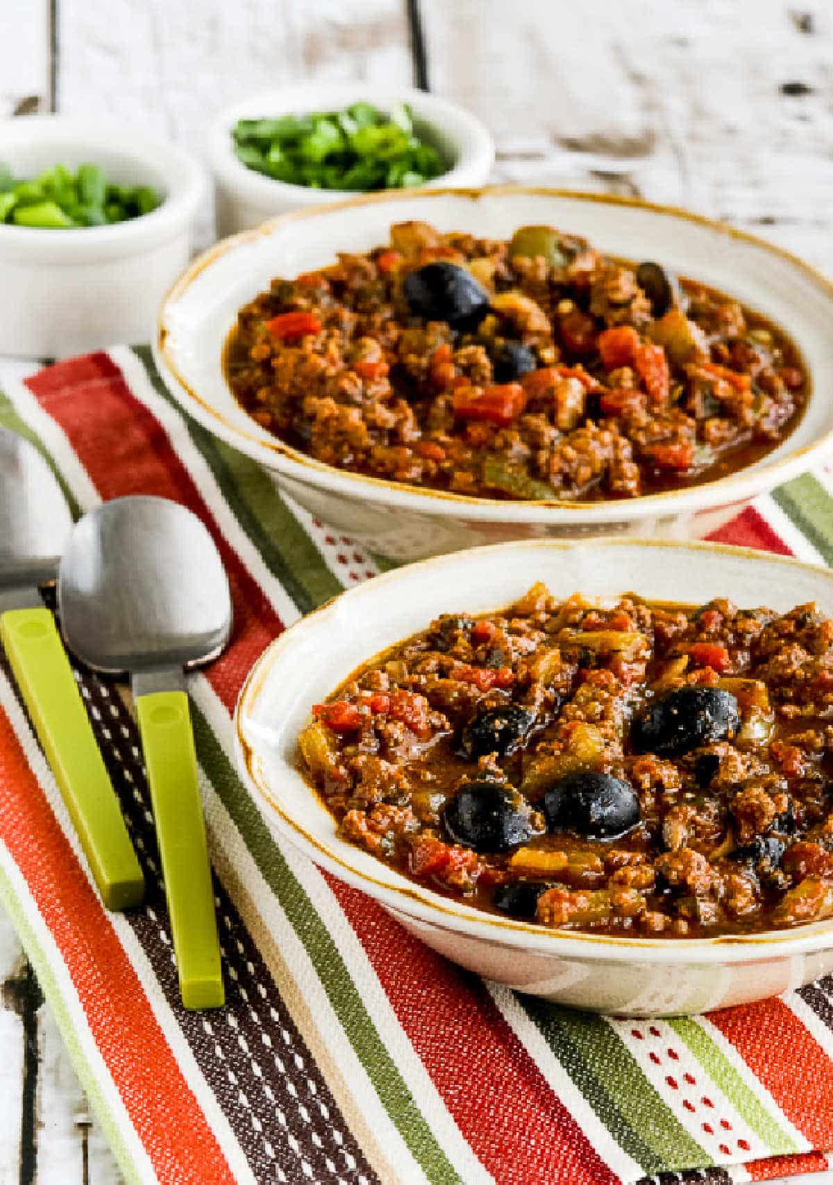 Pumpkin Chili with Beef, Peppers, and Olives in two serving bowls