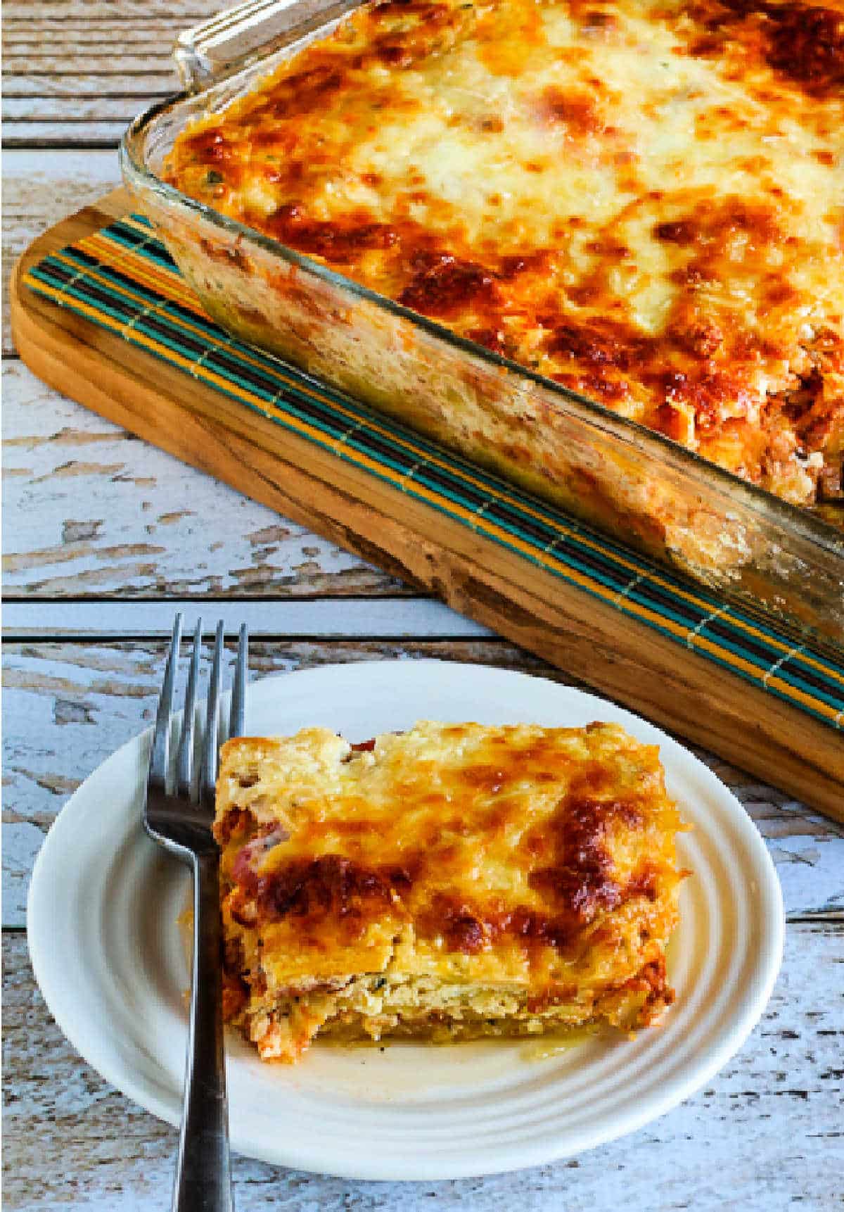 Mock Lasagna Spaghetti Squash Casserole with one serving on plate with fork and baking dish in back