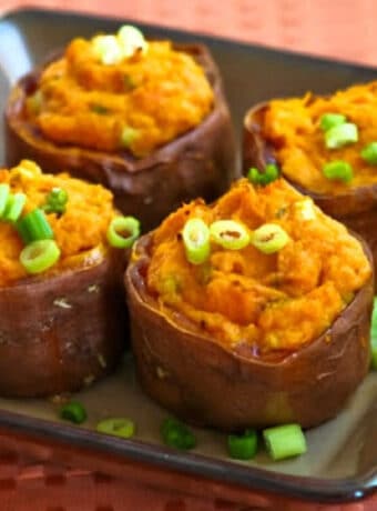 square image of twice-baked sweet potatoes on serving plate with green onion garnish